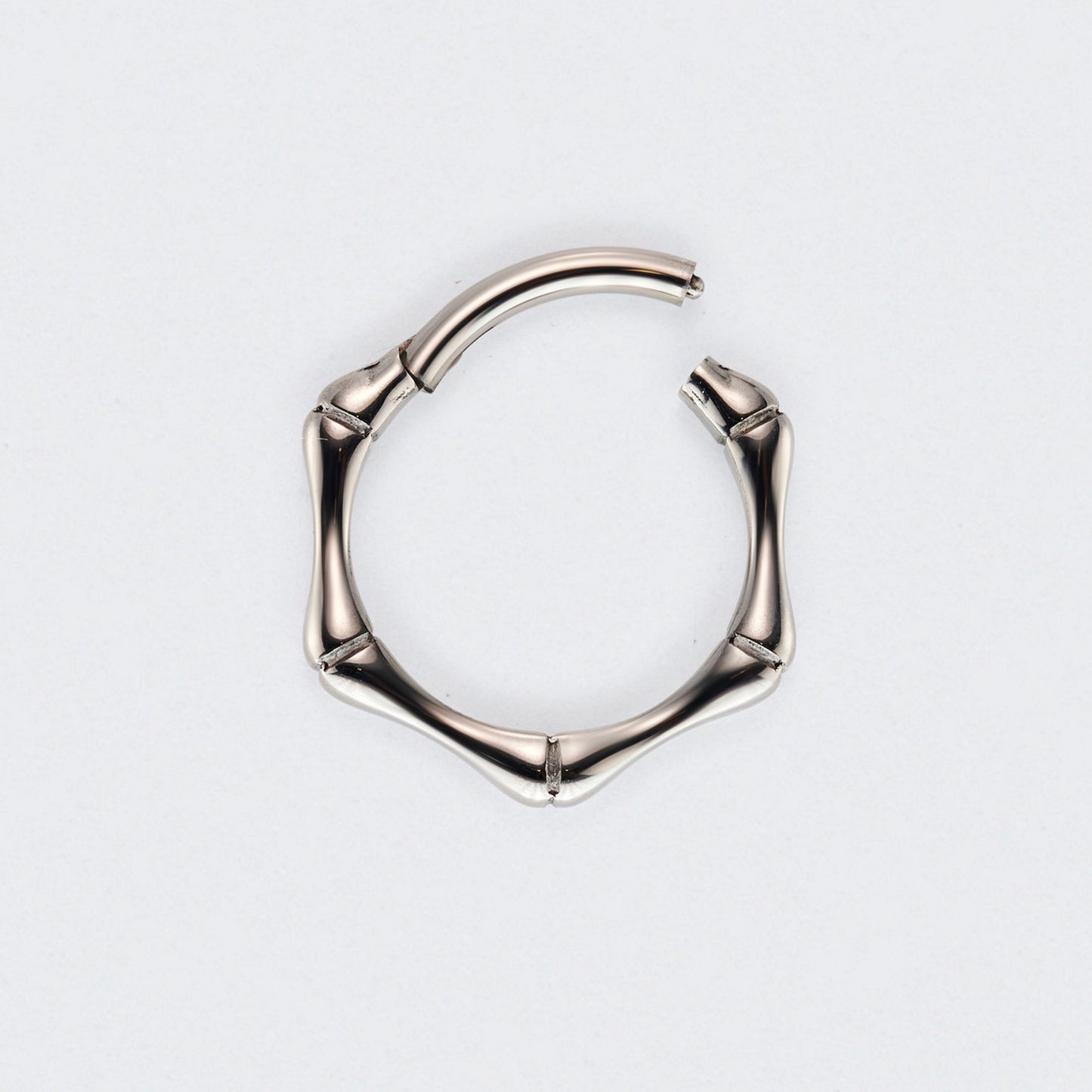 Silver hoop earring on a light grey background