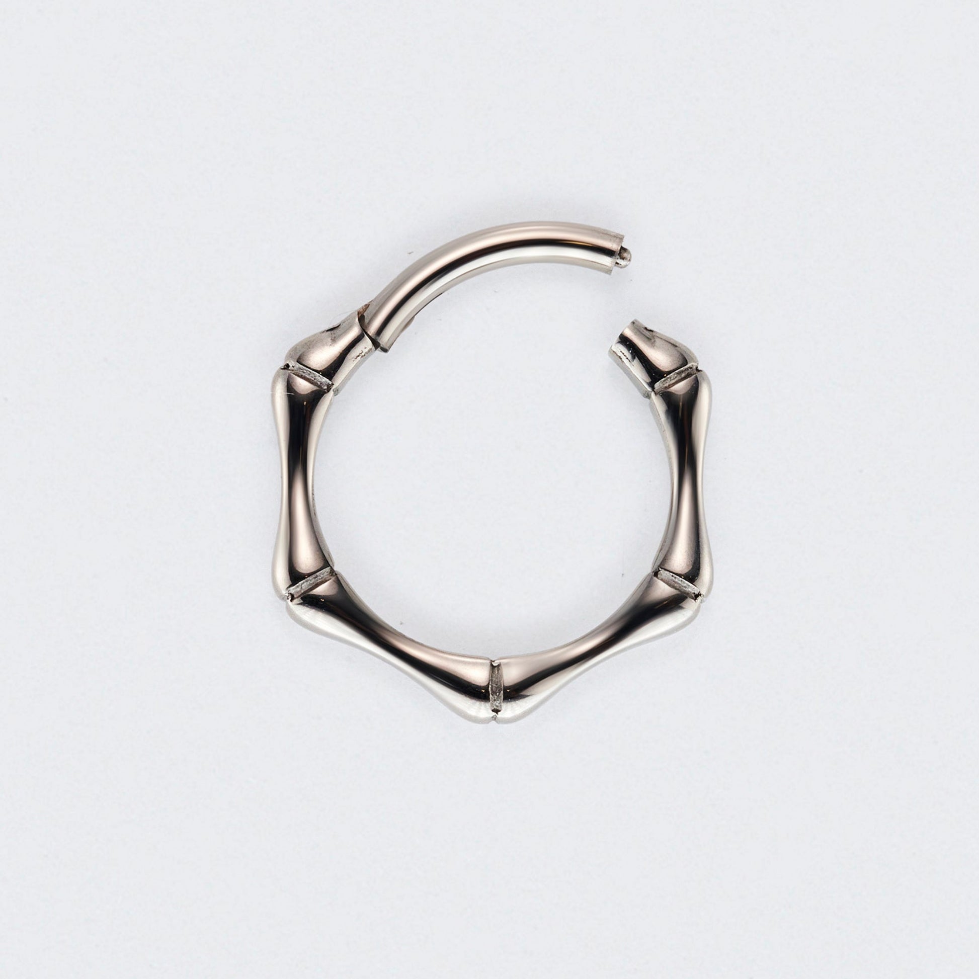 Silver hoop earring on a light grey background