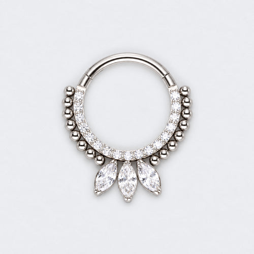A silver-toned hoop piercing ring decorated with small clear stones and three dangling marquise-cut clear stones, shown on a light gray background.