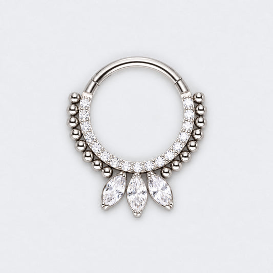 A silver-toned hoop piercing ring decorated with small clear stones and three dangling marquise-cut clear stones, shown on a light gray background.